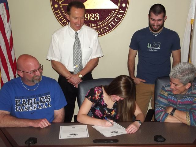Boling (at center) signs her letter of intent.